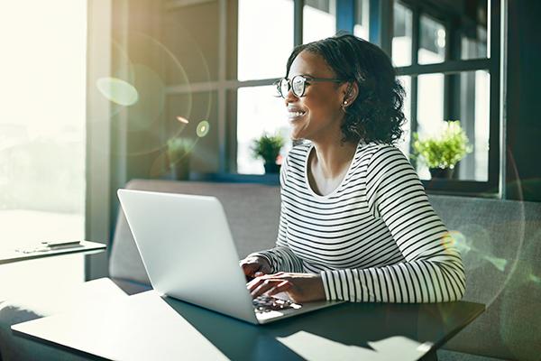 Woman working at a laptop in front of a window